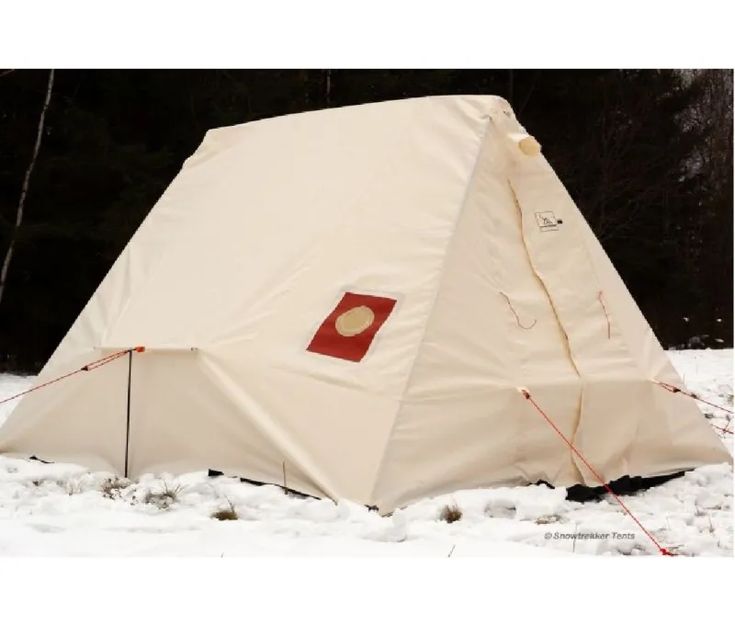 a white tent sitting in the snow next to trees