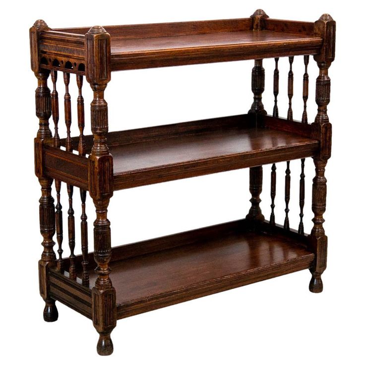 three tiered wooden shelf with spindles on the top and bottom, against a white background