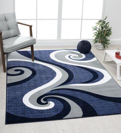 a blue rug with white swirls on it in front of a chair and window