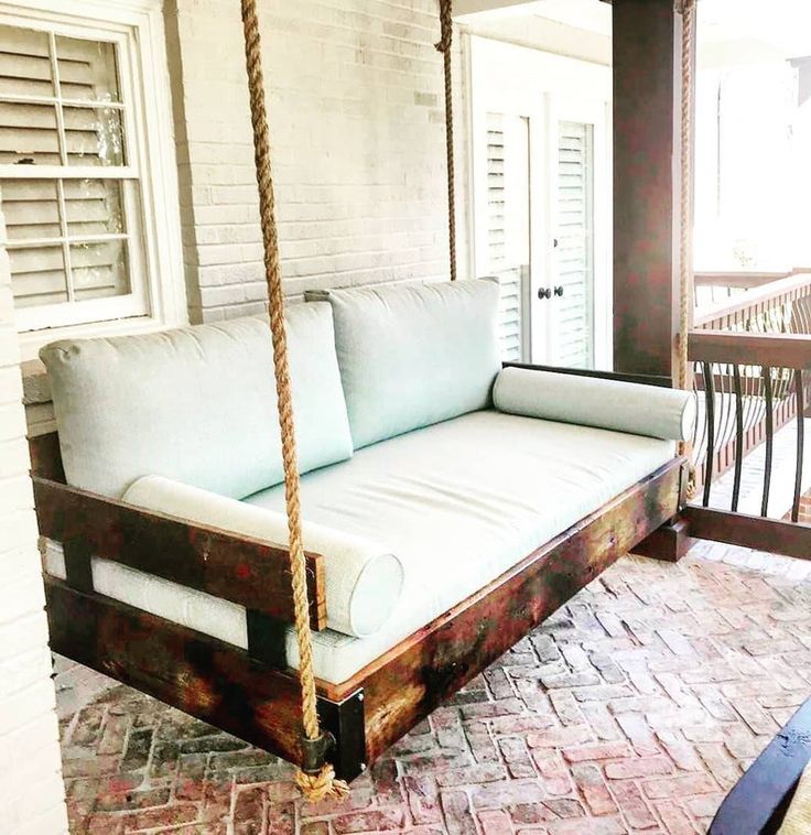 a porch swing bed with pillows on it