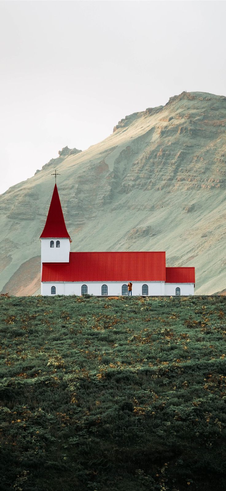 a red and white church on top of a hill