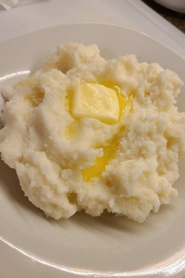 a white bowl filled with mashed potatoes on top of a table