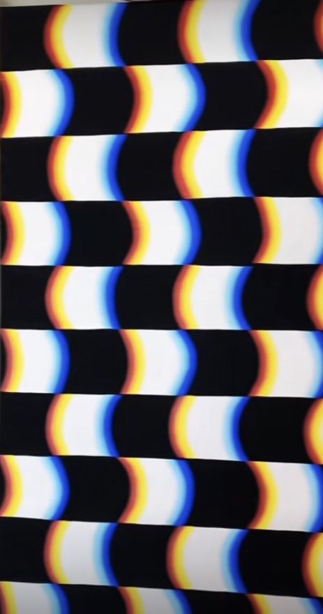 a black and white striped wall with multicolored circles on it