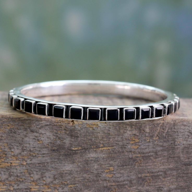 This bold and eye-catching bangle bracelet is the creation of Bhavesh in India. A sleek sterling silver circlet is studded with square-cut black onyx that totals 26 carats. The polished settings of the gems contrast beautifully with a darkly oxidized patina for a look that is all about contemporary chic. Modern Black Enamel Bracelet Jewelry, Modern Black Enamel Jewelry Bracelet, Modern Black Enamel Bracelet, Modern Black Bangle Jewelry, Nickel Free Black Bangle Jewelry, Adjustable Black Sterling Silver Stackable Rings, Black Sterling Silver Stackable Jewelry, Sterling Silver Stackable Rectangular Jewelry, Stackable Black Sterling Silver Jewelry