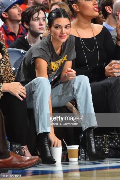 two women sitting next to each other in front of a crowd at a basketball game