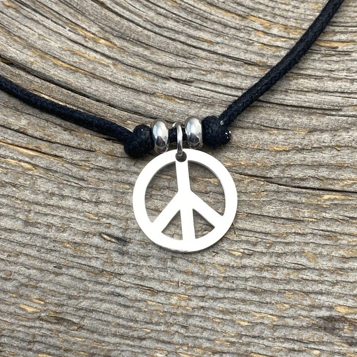 "Peace Sign Choker Pendant Peace Sign charm Charm is 17.5 mm approximately 3/4 inch, Non-Tarnish Stainless Steel Charm, beads, clasp, extender chain Black Natural Cotton cord, thick. Cord measure 14\" with 2\" extender total of 14\"- 16\" adjustable- custom sizes available Need Shorter or Longer cord? We have optional lengths available, message us we can customize for you Matching Earrings and Bracelets available M O R E ∙ I N S P I R E D ∙ D E S I G N S www.etsy.com/shop/BeInspiredUP ⓒ All Desi Minimalist Adjustable Charm Necklaces, Stainless Steel Adjustable Choker, Minimalist Adjustable Charm Necklace, Adjustable Hypoallergenic Metal Necklaces, Adjustable Stainless Steel Charm Necklaces With Lobster Clasp, Adjustable Metal Round Charm Necklaces, Minimalist Adjustable Charm Necklace With Lobster Clasp, Adjustable Round Charm Necklace Nickel Free, Adjustable Nickel-free Round Charm Necklace