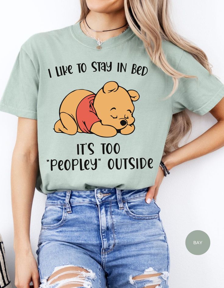 Wrap yourself in the warmth of relaxation with our "Cozy Hibernation Retreat Tee." This delightful shirt features Winnie the Pooh in his favorite spot, snug in bed, declaring, "I like to stay in bed. It's too peoply outside." Embrace the comfort of solitude and let the world outside fade away as you enjoy the tranquility of your own cozy sanctuary. Casual Cartoon Print Sleep Top, Casual Sleep Tops With Cartoon Print, Cute Tops For Lounging, Comfortable Crew Neck Bedtime Tops, Comfortable Crew Neck Top For Bedtime, Casual Letter Print Top For Bedtime, Cute Sleep Tops With Cartoon Print, Cute Cartoon Print Sleep Tops, Casual Crew Neck T-shirt For Bedtime