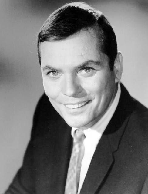 a black and white photo of a man in a suit with a smile on his face