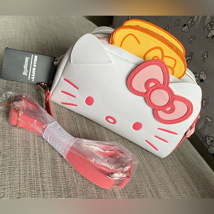 a hello kitty purse and its contents on a couch