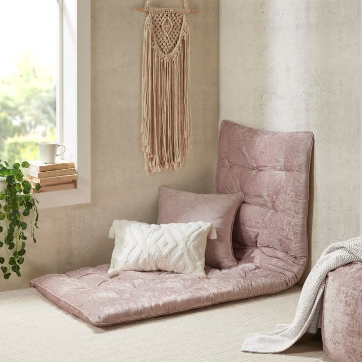 a living room with two pink chairs and a white rug on the floor next to a window