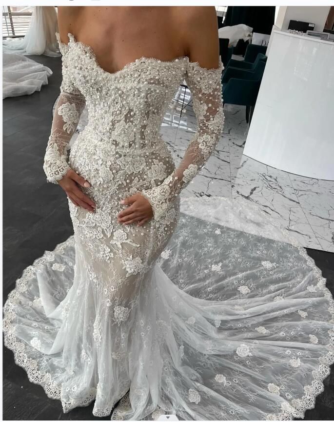 a woman in a white wedding dress is posing for the camera with her hands on her hips