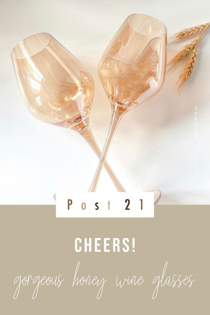 two champagne flutes with the words cheers on them and wheat stalks in front of it