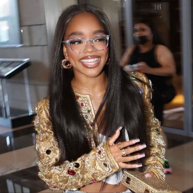 a woman with long hair and glasses is smiling