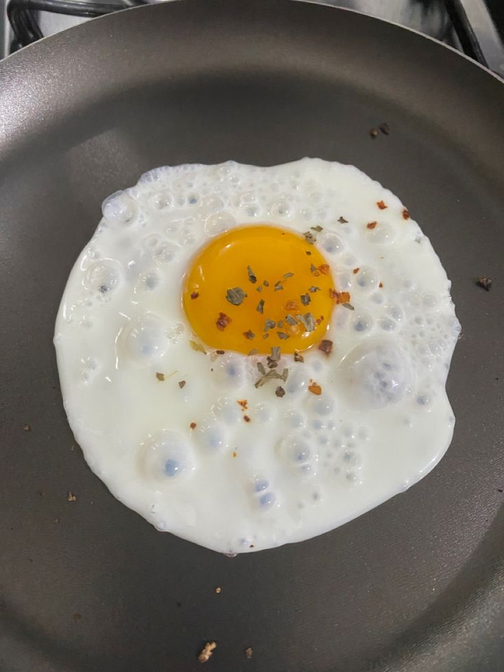 an egg is fried in a frying pan on the stove