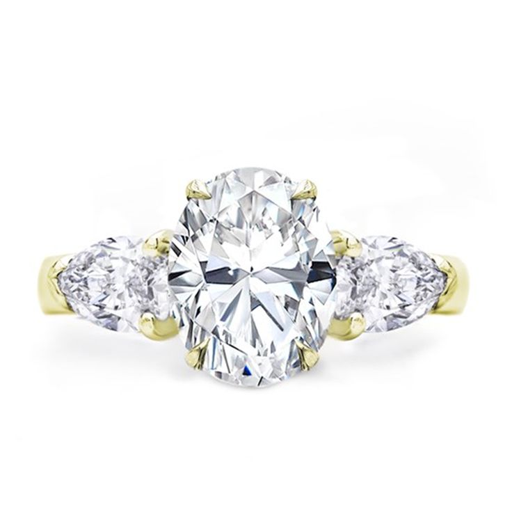 a three stone diamond ring with two pear shaped diamonds on the band and side stones