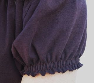 a person wearing a purple shirt with ruffles on the sleeves and bottom half