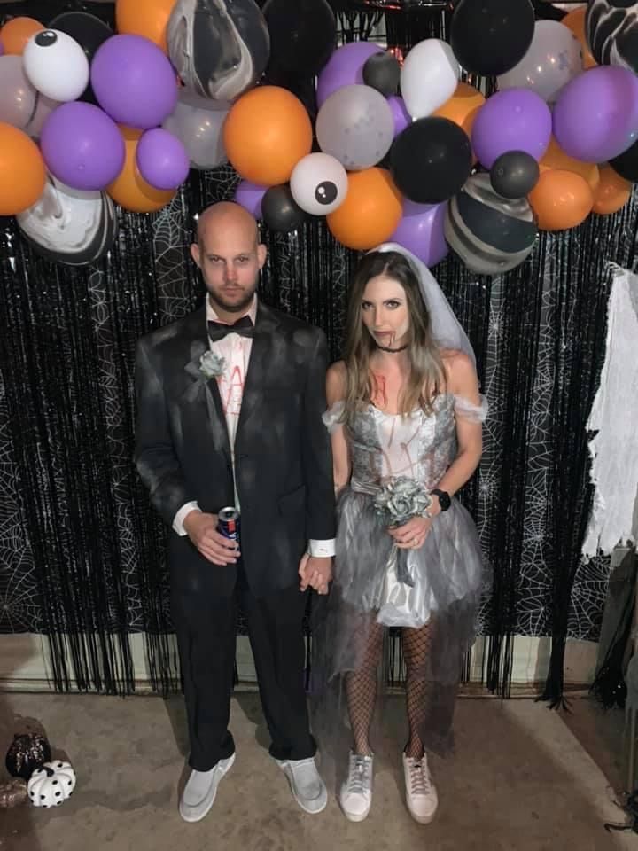 a man and woman standing next to each other in front of balloons