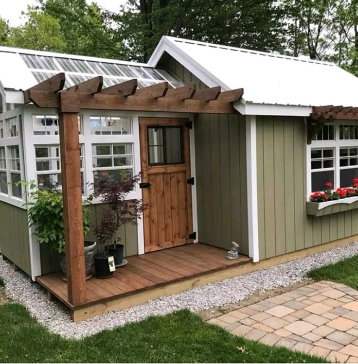 a small shed with a wooden door and windows