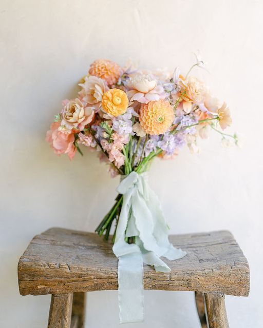 a bouquet of flowers sitting on top of a wooden bench