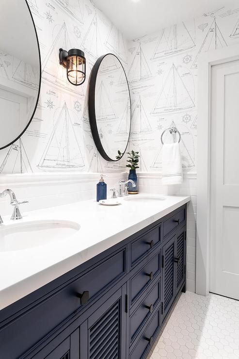 a bathroom with two sinks and mirrors on the wall above it is decorated in white and blue