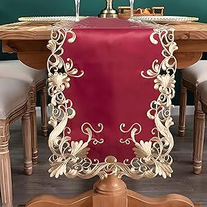 a red table cloth on top of a wooden table with white chairs and a wine glass holder