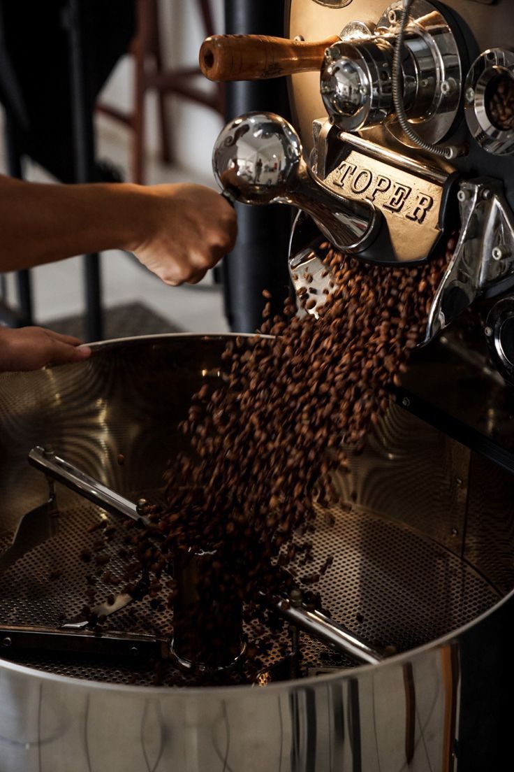 a person pouring coffee into a metal bowl