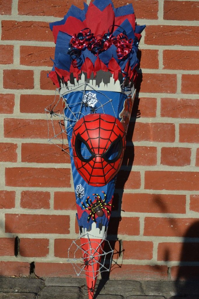 a spiderman mask is attached to a brick wall with barbed wire on the sides