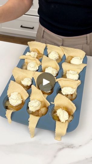 a person is preparing some food on a blue tray with white frosting in the middle