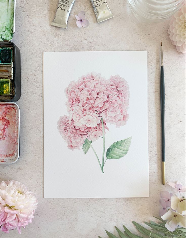 pink flowers and watercolors are on the table