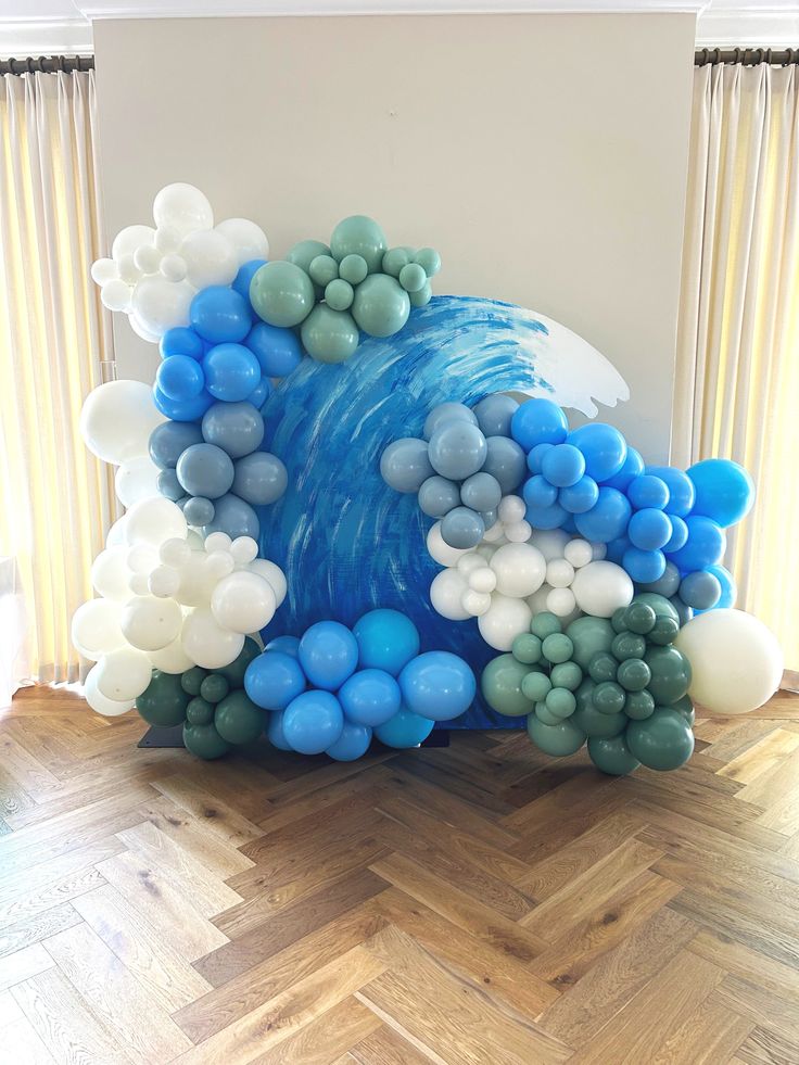 an ocean themed balloon sculpture in the shape of a wave with blue and white balloons