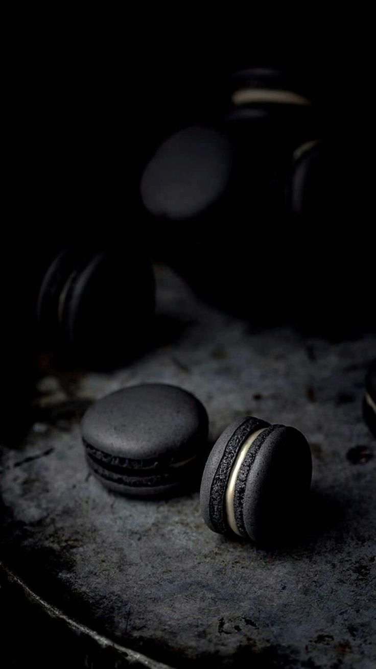 two black macaroons sitting on top of a table