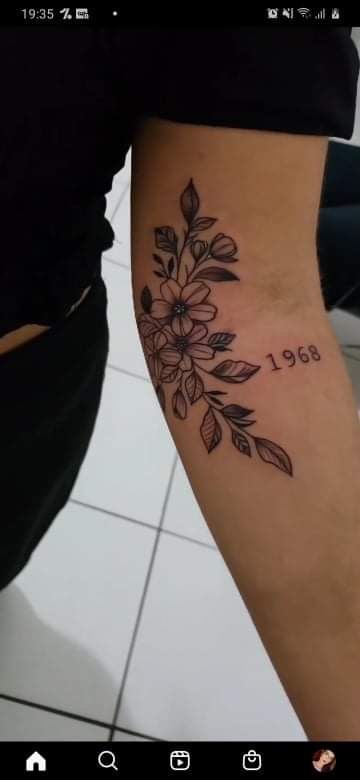 a woman's leg with a flower tattoo on her left arm and the number 661 written in black ink