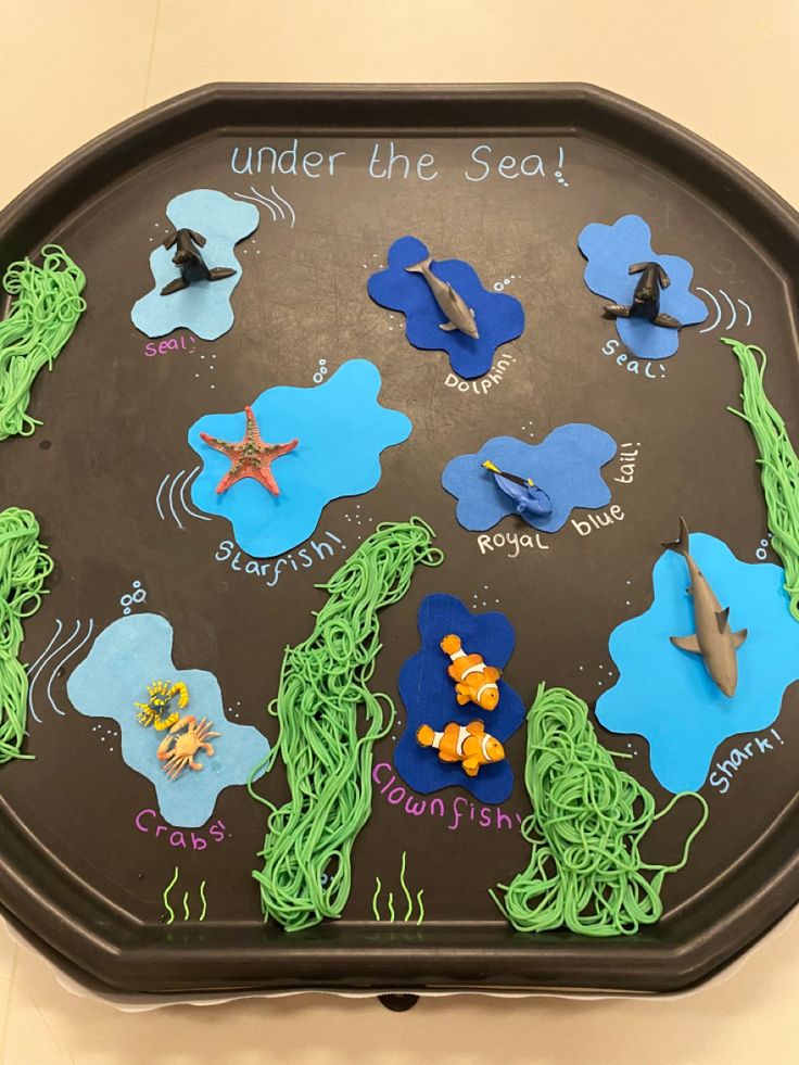 under the sea activity tray with ocean animals and fish on it for children to play