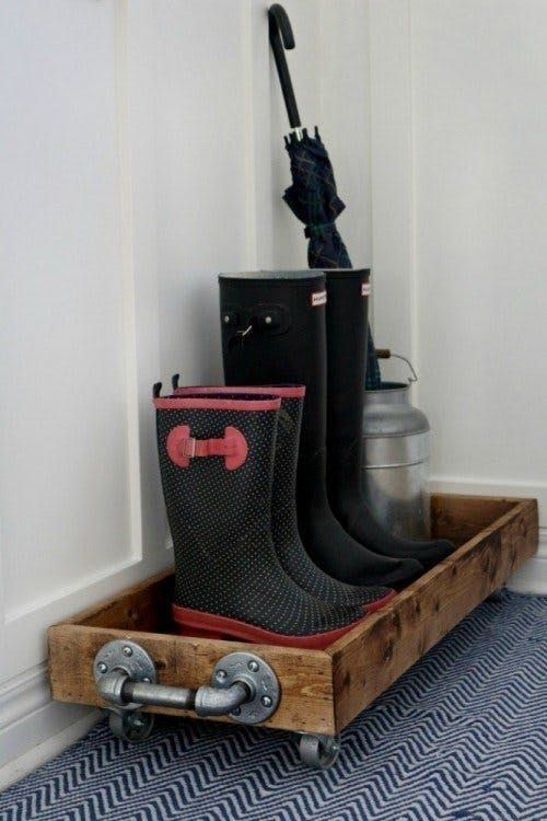 a pair of rain boots sitting on top of a wooden crate in front of a wall