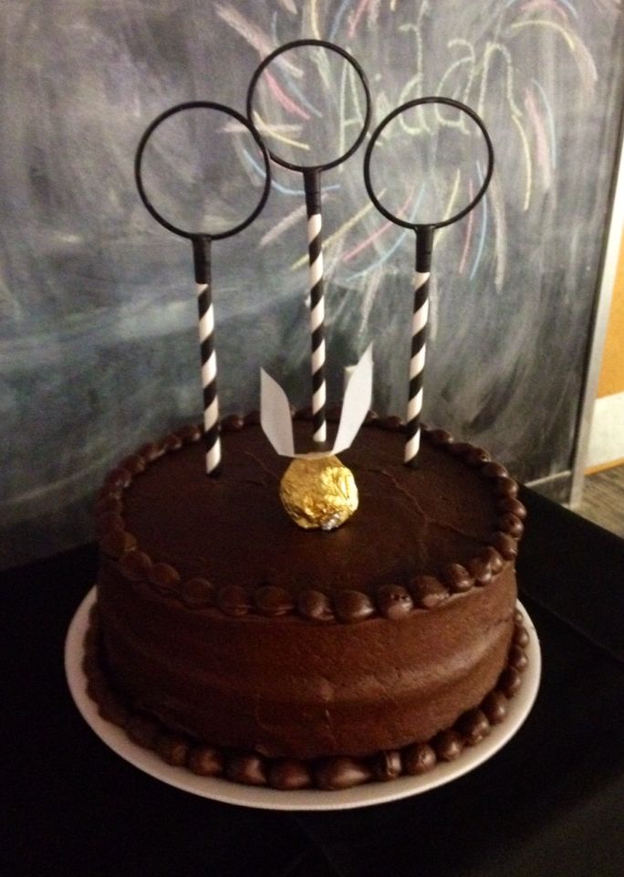 there is a chocolate cake with three candles on it and some candy sticks sticking out of the top