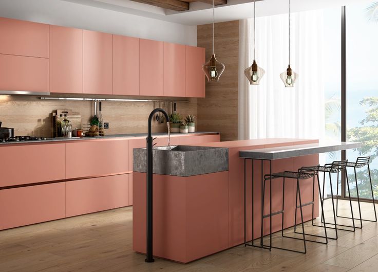 a kitchen with pink cabinets and an island in the middle, along with bar stools