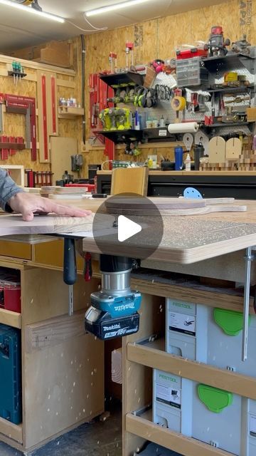 a man working on a table in a shop with tools and other workbenches