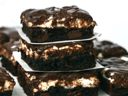 four chocolate brownies with marshmallows on top are stacked up in the shape of squares