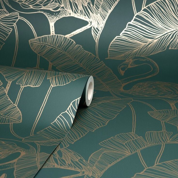 a green wallpaper with gold leaves and birds on it's side, as well as a roll of tape