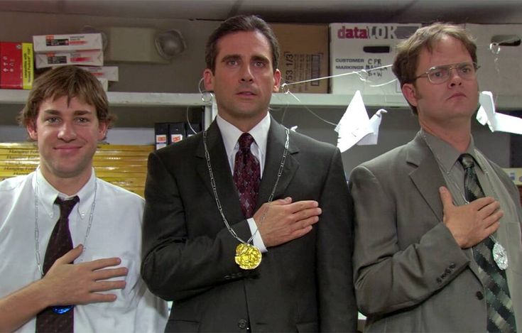 three men in suits standing next to each other with their hands on their chests