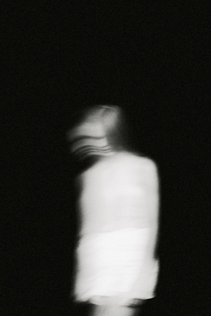 a blurry image of a person standing in the dark