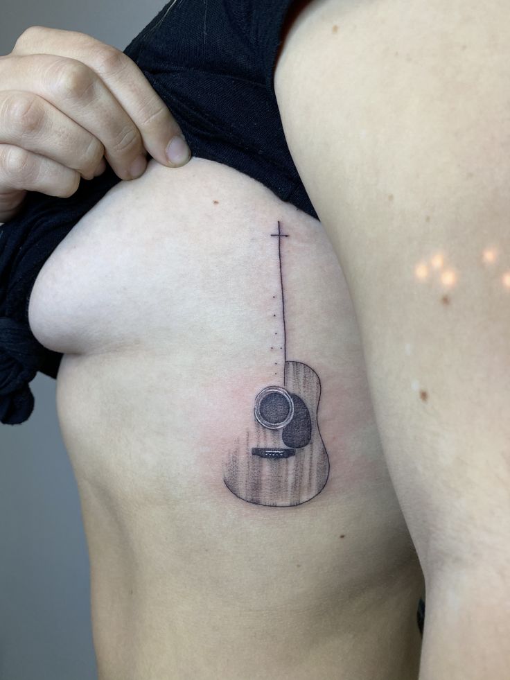 a woman with a guitar tattoo on her stomach