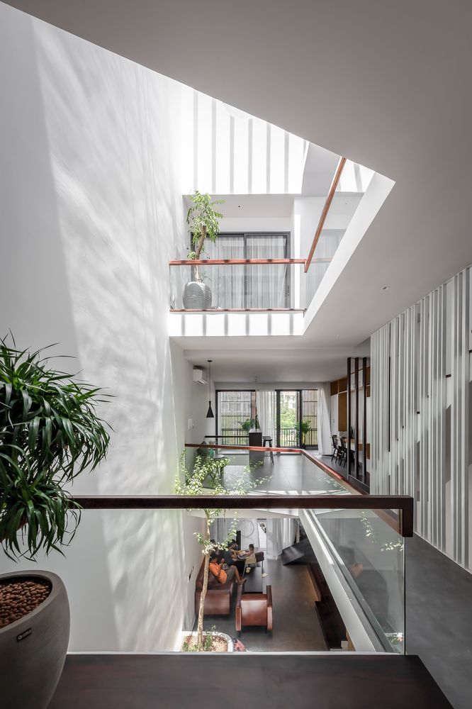 the interior of a modern house with glass railings and plants on the balconies