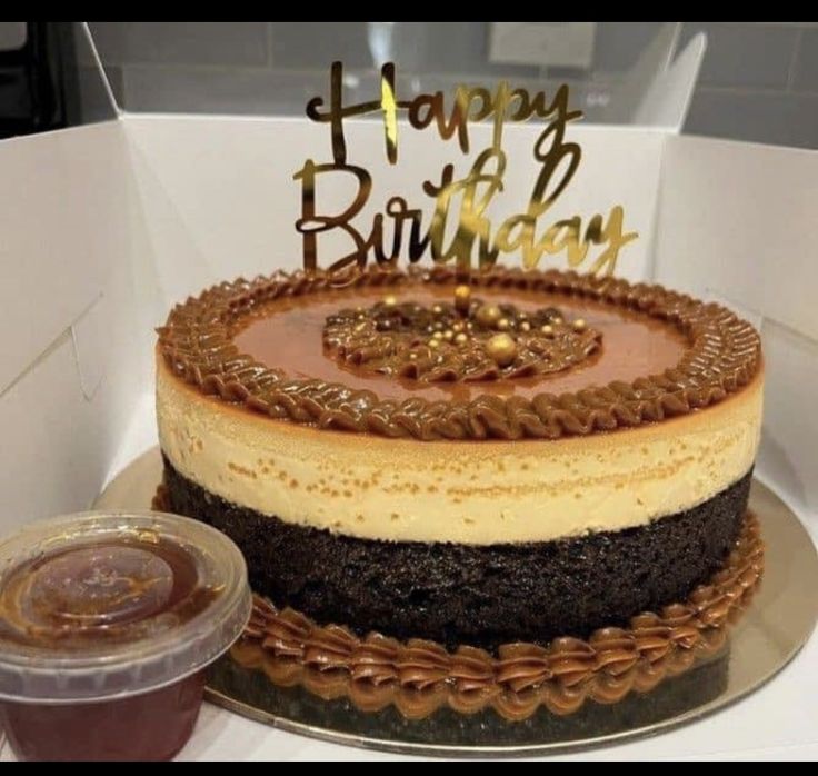 a birthday cake sitting on top of a table next to a plastic cup and saucer