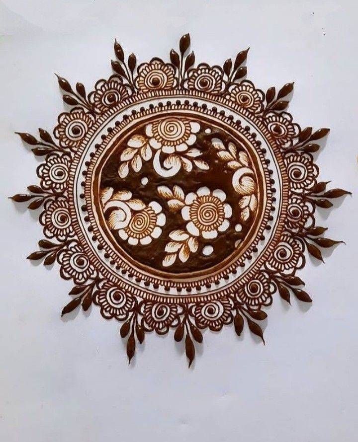 an intricately designed wall hanging on the side of a white wall with flowers and leaves