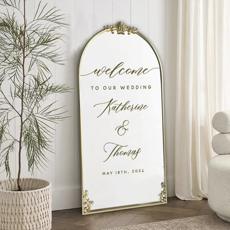 a wedding welcome sign in front of a potted plant