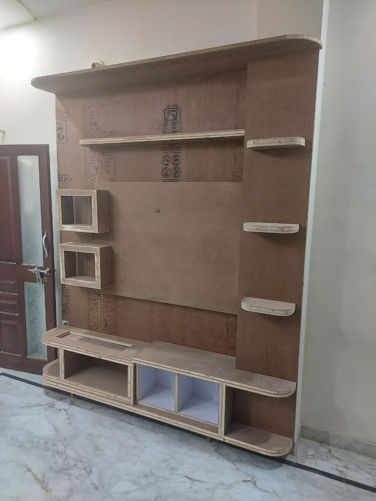 an unfinished entertainment center in the middle of a room with doors and shelves on both sides