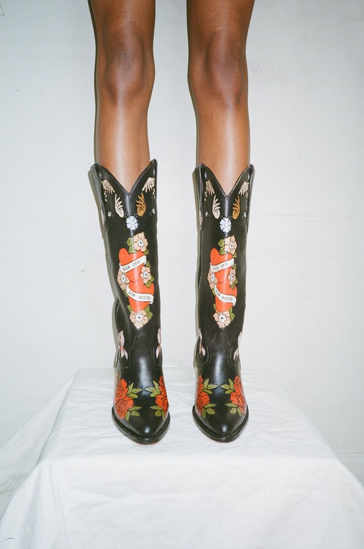 The Brother Vellies Doodle Boots have been a long-time fan favorite. They are one-of-a-kind works of art handmade and hand painted with love by Artisans in Mexico. From its inception, Brother Vellies has been dedicated to advocating for women’s rights. After the Supreme Court overturned Roe v Wade, effectively stripping women of the right to bodily autonomy and access to abortion, Aurora James was inspired to create a collection dedicated to Women and their fight for bodily autonomy to fight aga Cowboy Boots And Bathing Suits, Custom Made Cowboy Boots, Brother Vellies Shoes, Brother Vellies Boots, Western Chic Fashion Dressy, Art On Clothes Paint, Cowboy Editorial, Cowgirl Boots Art, Aurora James