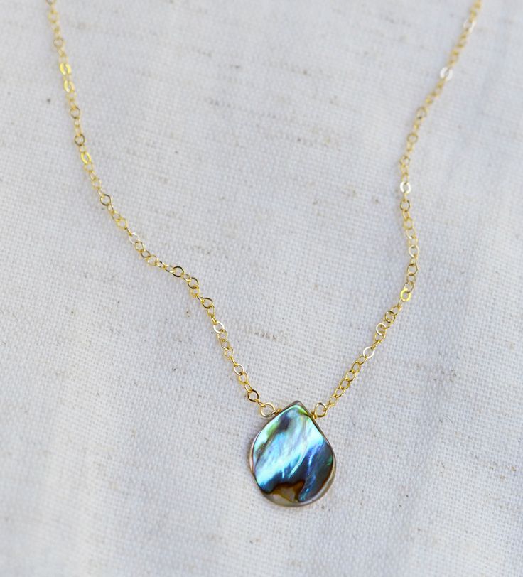 Looking for a unique necklace that captures the essence of the ocean and promotes feelings of peace and beauty? Look no further! Our handcrafted pendant features a teardrop-shaped genuine abalone shell in shades of green, blue, pink, cream, purple, and brown. Available in both sterling silver and 14k gold filled. It's the perfect gift for beach lovers!*The reverse side of the abalone is a tan color and can have natural imperfections along its surface. Pendant Size: average .75 x .5 inches (17x12mm)Modeled Size: 15 inches Adjustable Teardrop Pearl Pendant Jewelry, Turquoise Necklace With Pearl Drop As Gift, Turquoise Necklace With Pearl Drop For Gift, Bohemian Teardrop Pendant Drop Necklace Gift, Mother Of Pearl Drop Jewelry For Gift, Drop-shaped Mother Of Pearl Jewelry For Gifts, Handmade Teardrop Abalone Shell Jewelry, Teardrop Pearl Drop Necklace For Gift, Handmade Spiritual Teardrop Drop Necklace