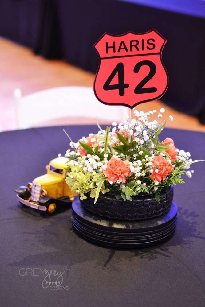 a table topped with a flower pot and a sign that says haris 42 on it